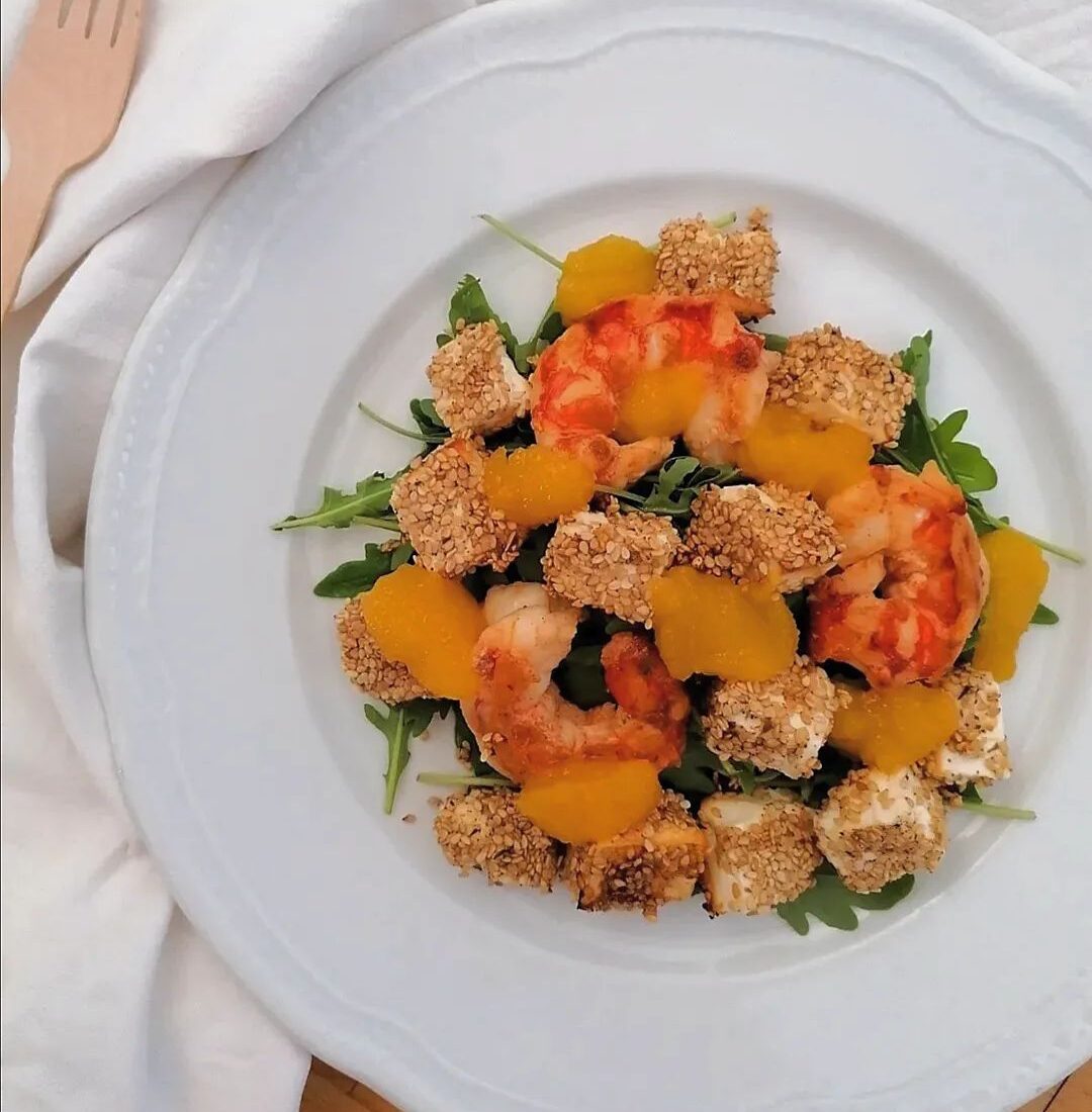 Insalata con rucola, feta al sesamo, gamberi, salsa al mango e passion fruit